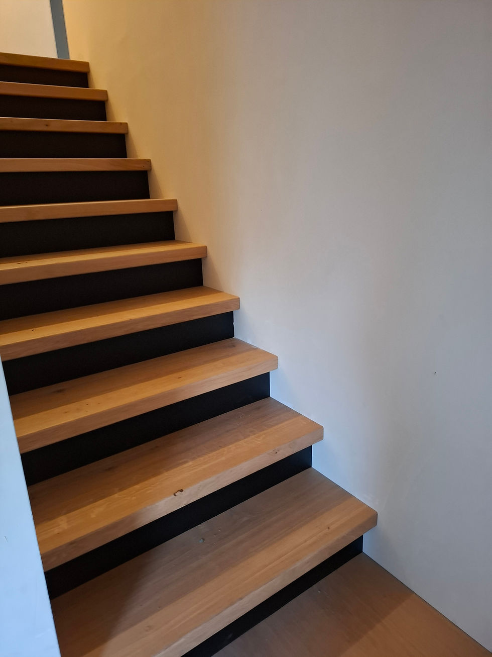 Klassieke eiken trap met zwarte stootborden.