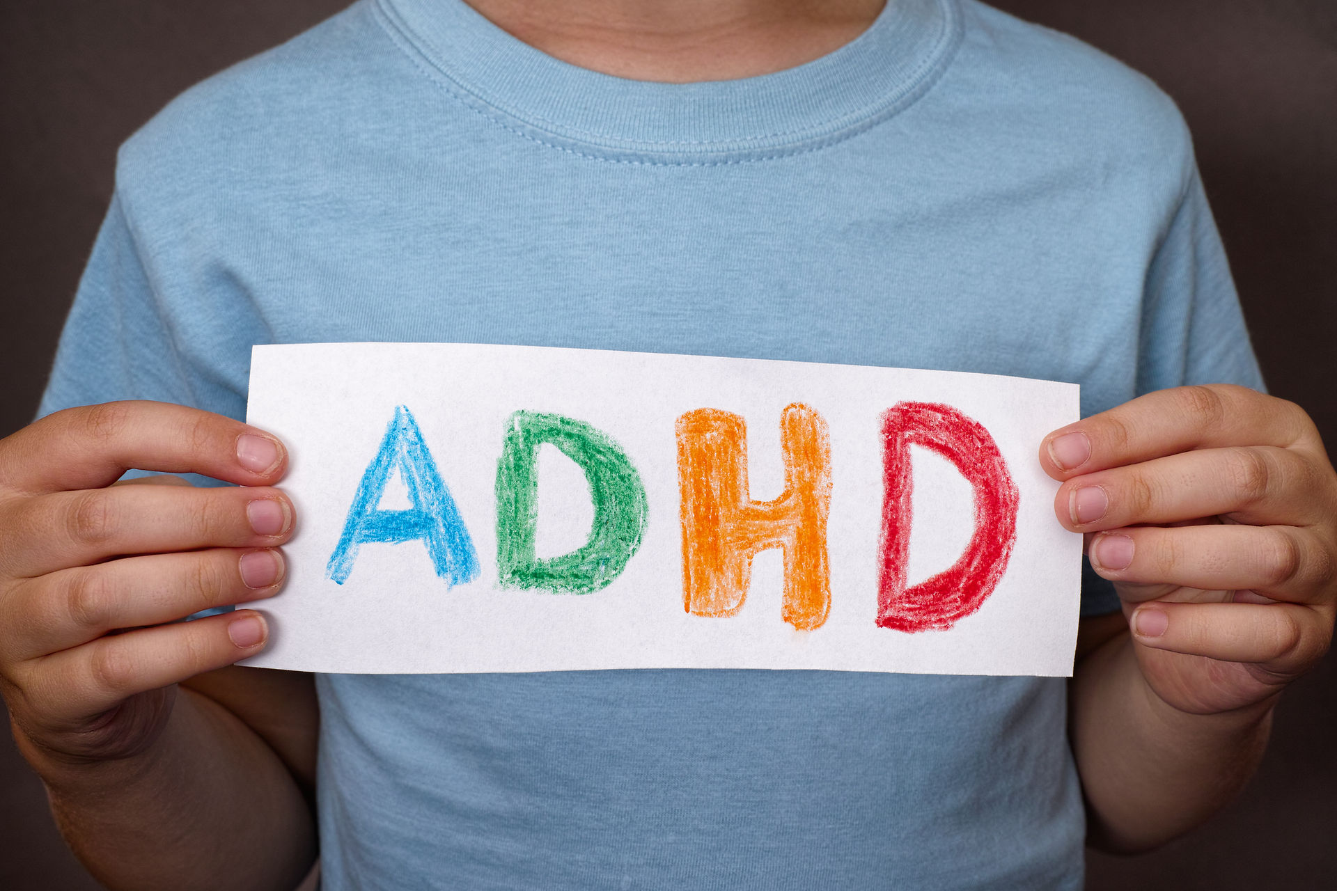 Young boy holds ADHD text written on she