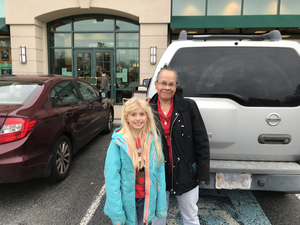 Gloria and her daughter pose for a picture in a parking lot