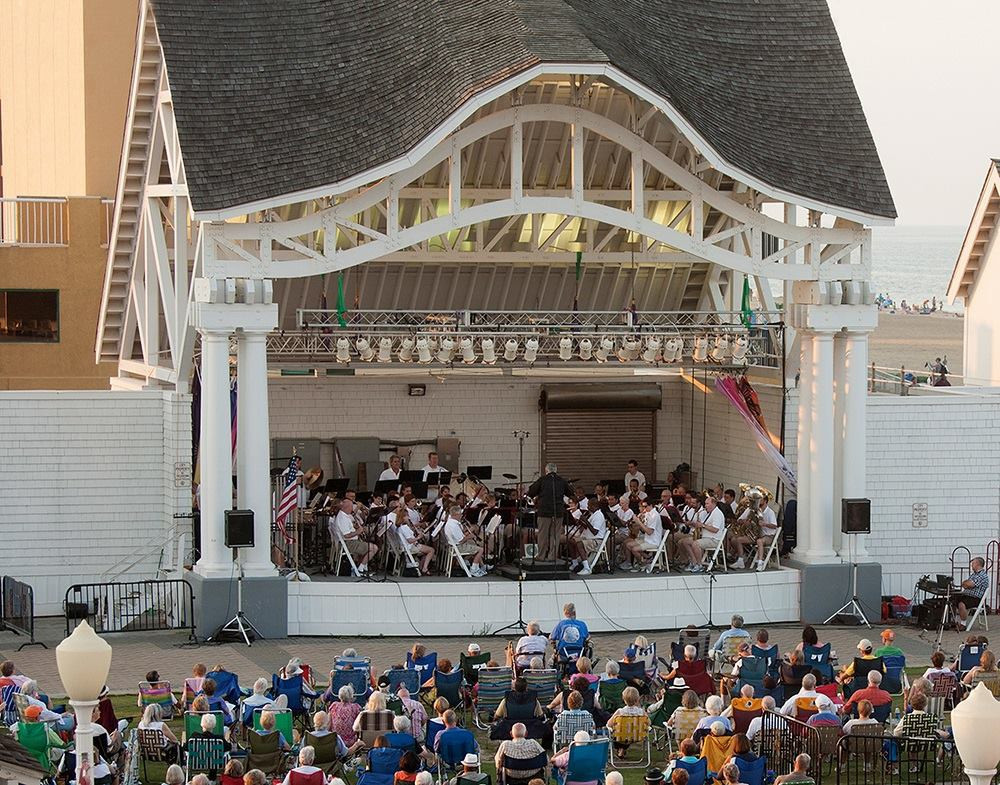 Tidewater winds plays at an outdoor venue, the stage from far away with some crowd in front
