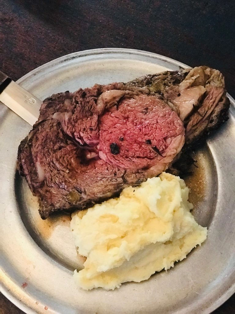 Some kind of rare beef with mashed potatoes