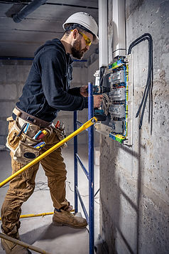 male-electrician-works-switchboard-with-electrical-connecting-cable.jpg