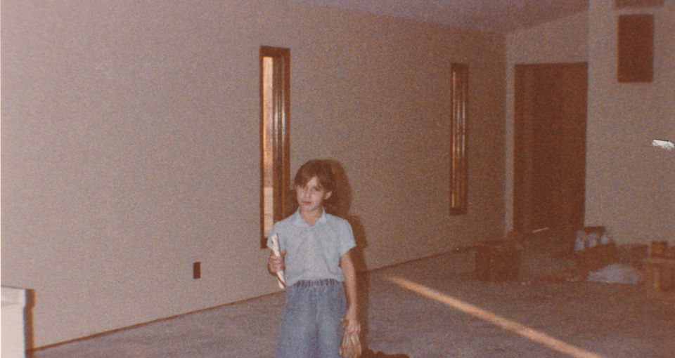 Young girl standing in empty room, construction is visible; old photo.