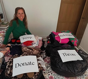 Alix sat on a bed sorting clothes into piles to sort what to keep, donate or throw