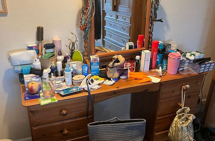 Dressing Table cluttered with bottles, sprays, brushes and accessories