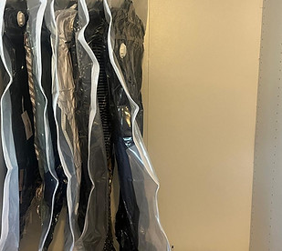 Clothes in a Wardrobe Packed in Space Saving Bags.