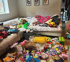 Childs bedroom covered in toys, the floor and bed are hardly visible.