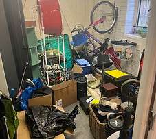 Garage before being organised, piled high with bkes, weights, shoes, bags and sports equipment.