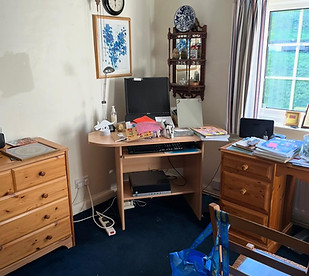 Cluttered Desk area in the corner of a Bedroom