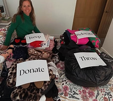 Alix sat on a bed organising clothes into categories.