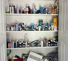 Chaotic cupboard full of bottles, cans, packets and toiletries.