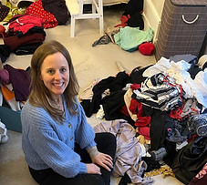 Alix from Decluttering Crew sorting a pile of clothes
