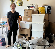 Alix stood with a stack of packed Boxes