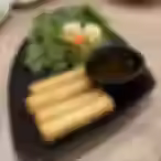 Vietnamese crispy egg rolls served with fresh herbs, lettuce, and dipping sauce