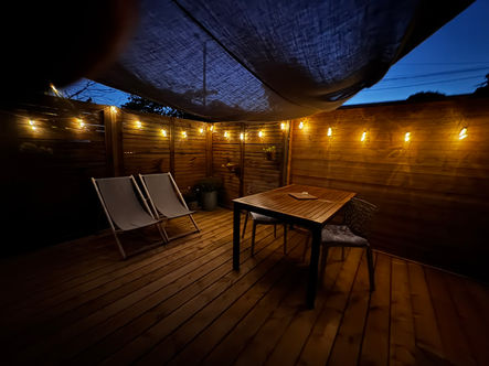 Terrasse privée avec transats, table et chaises, plancha, voile d'ombrage