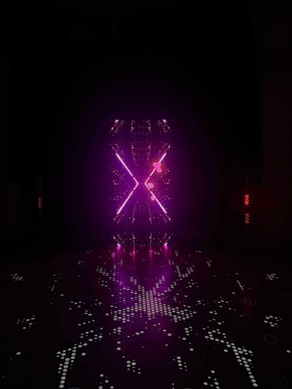 Abstract X-shaped light installation in a dark space, Perceive or Receive (2025) by Elin Fiorentino