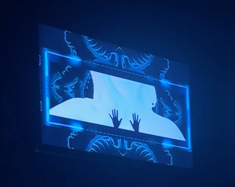 Blue illuminated screen showing a human torso silhouette with two small hand shapes on the chest