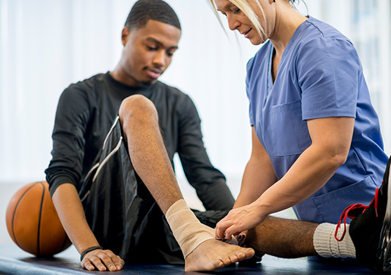 Basketball player receiving ankle treatment for a sports-related injury