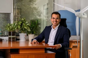 lifestyle portrait of a CEO with ambient, office backdrop shot by a professional photographer in Delhi NCR.