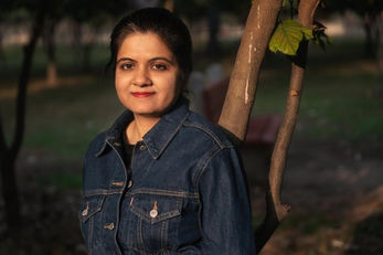 Headshot of a life coach with natural backdrop for use on her website and LinkedIn profiles