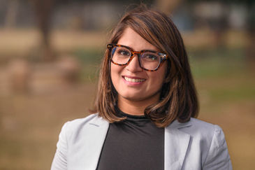 Headshot of an artist with natural backdrop for use on her website.