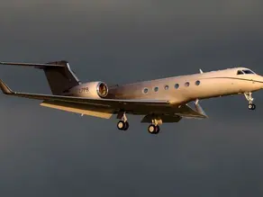 Sleek wing and engine of a private charter aircraft flying high above the clouds at cruise altitude