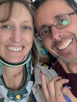 Amy in her cervical collar with her new scar showing and Justin with his finger with stitches in it.
