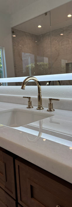 White sink and faucet with a wooden cabinet and Bathroom Remodeling.
