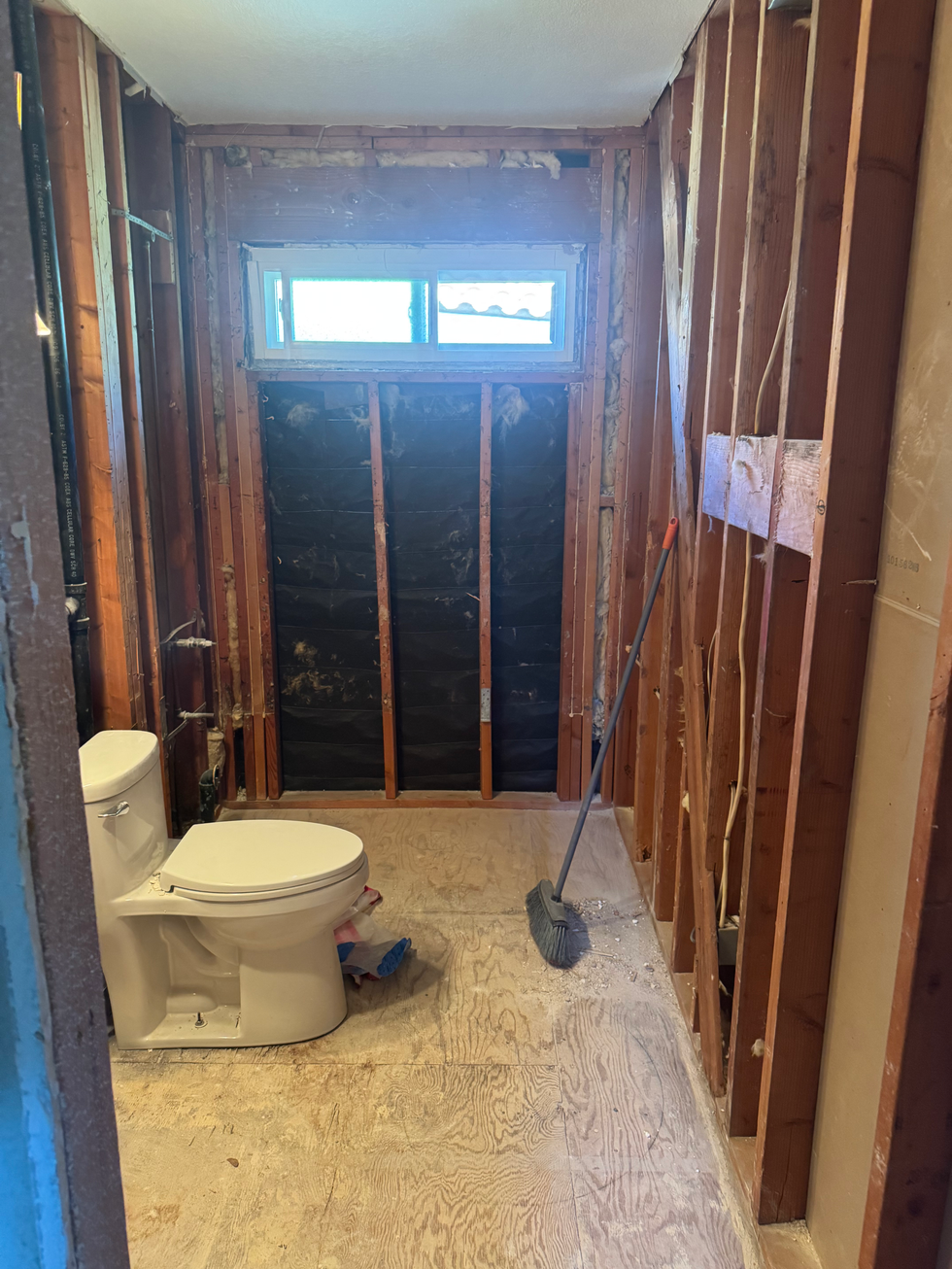 In-progress bathroom renovation in RSM showing shower pan installation and wall prep.