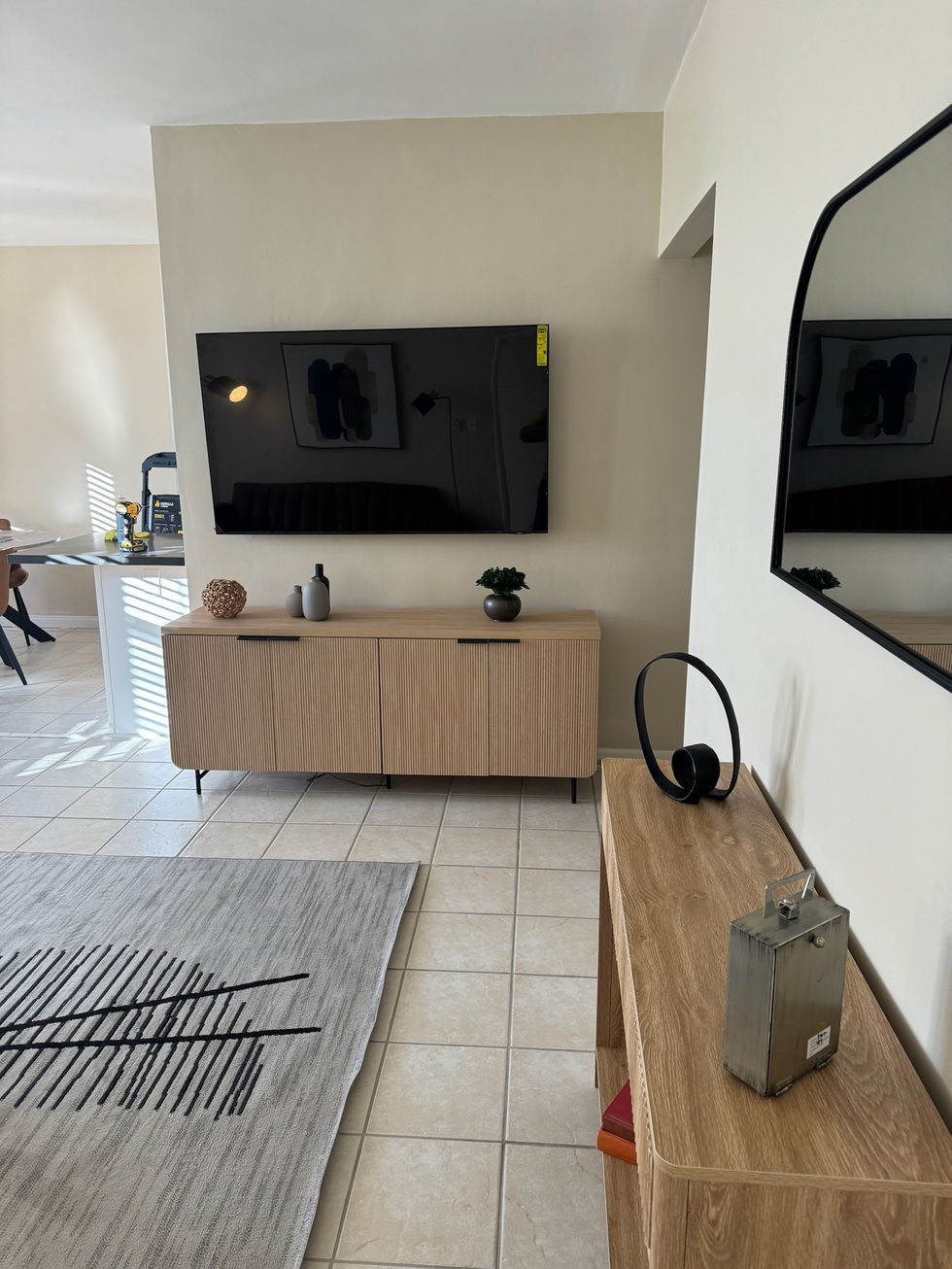 A close-up of a custom-built wooden media unit with integrated shelving and a mounted large-screen TV.