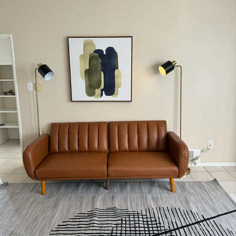 A wide-angle shot of a completed living room renovation with neutral tones and large windows.