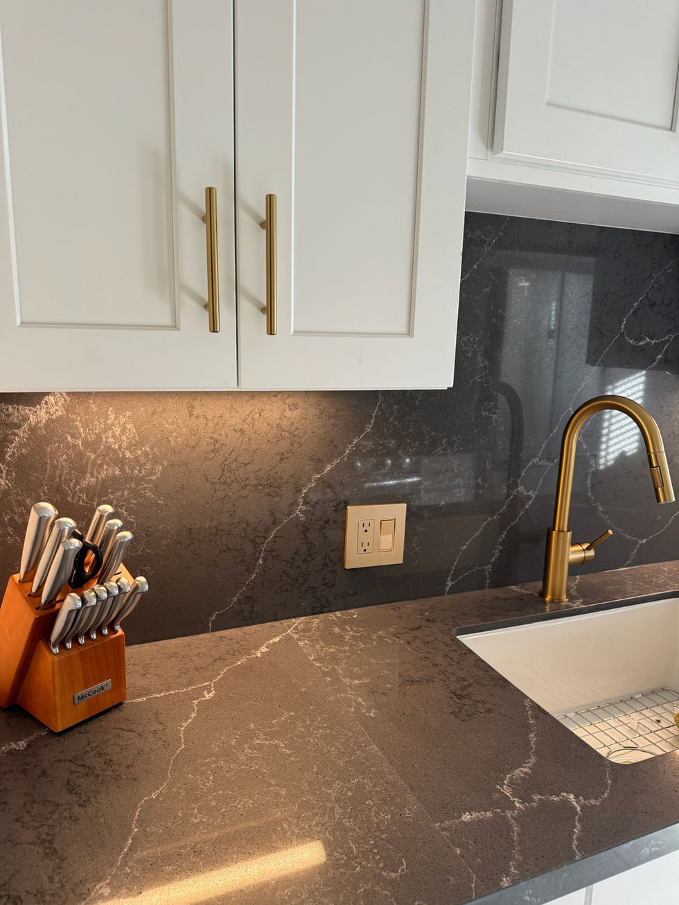 A finished kitchen renovation showing the contrast between dark island cabinets and light perimeter cabinetry.