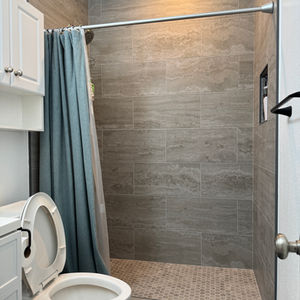 Looking into a remodeled bathroom from the master bedroom doorway, showing the layout and lighting.