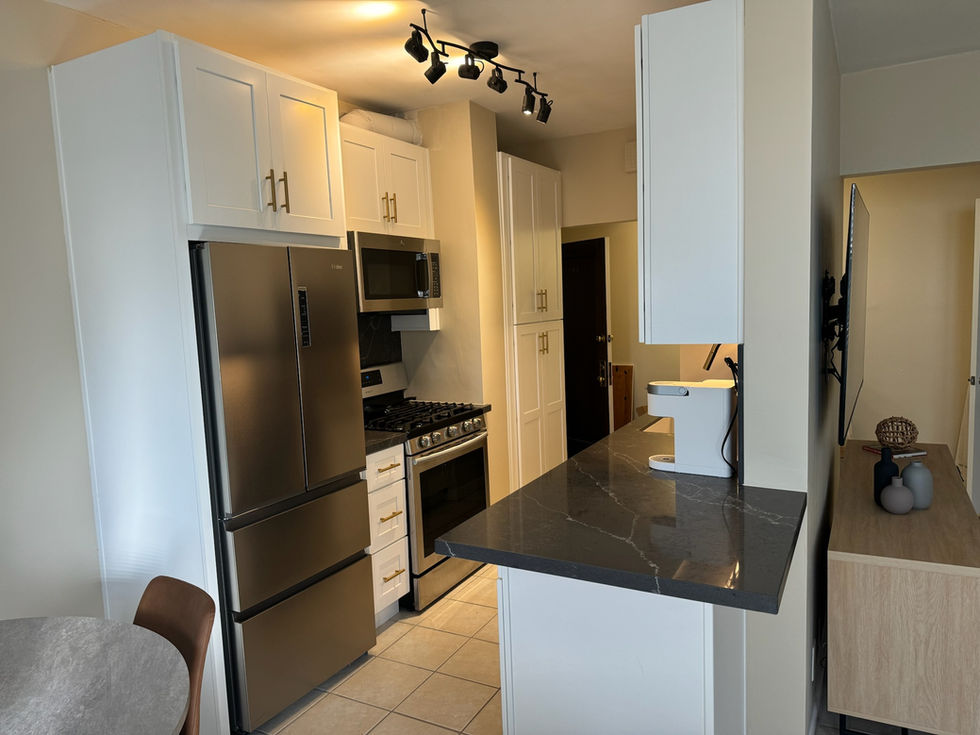 A bright, open kitchen featuring a marble-style backsplash and designer pendant lighting.
