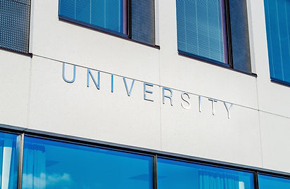 A school building with "UNIVERSITY" on the outer wall and rooms with windows