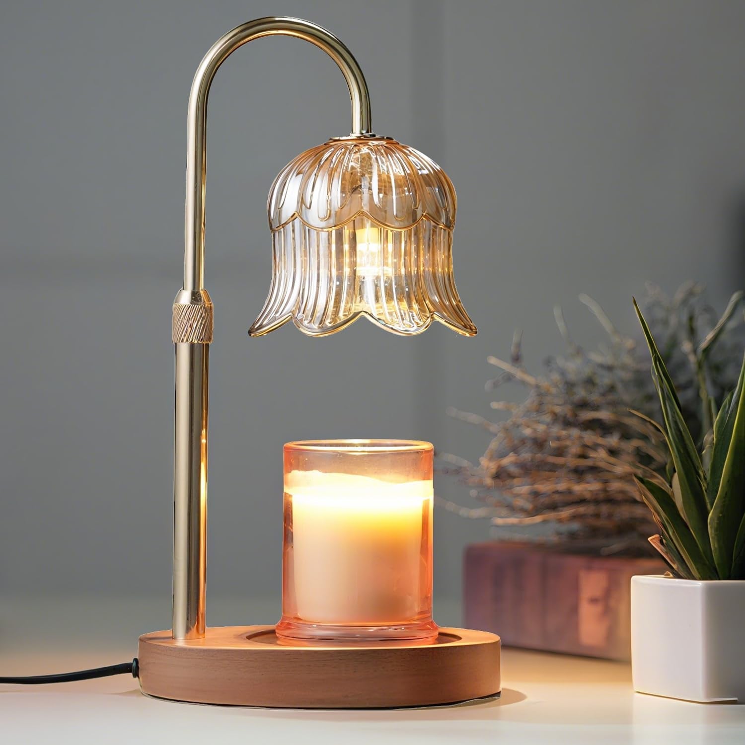 Decorinio candle warmer lamp with amber glass shade glowing over a lit jar candle