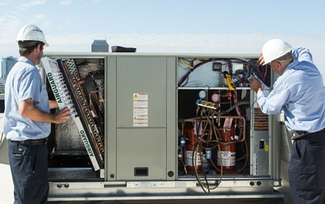 Commercial HVAC maintenance technicians servicing rooftop HVAC units