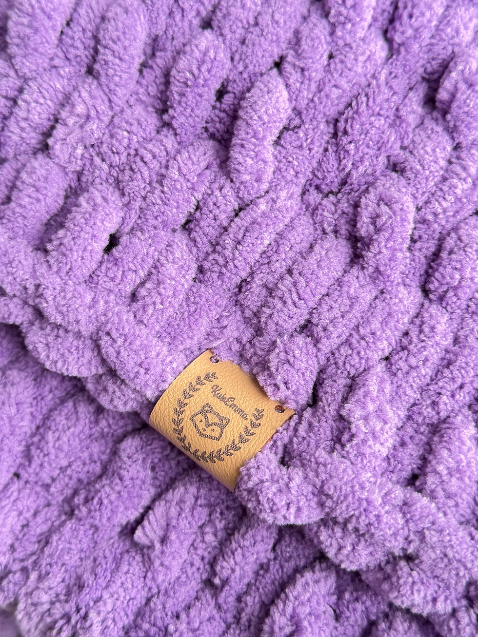 Miniaturbild: detail der Marke auf einer kuscheliger handgemachter lila Babydecke