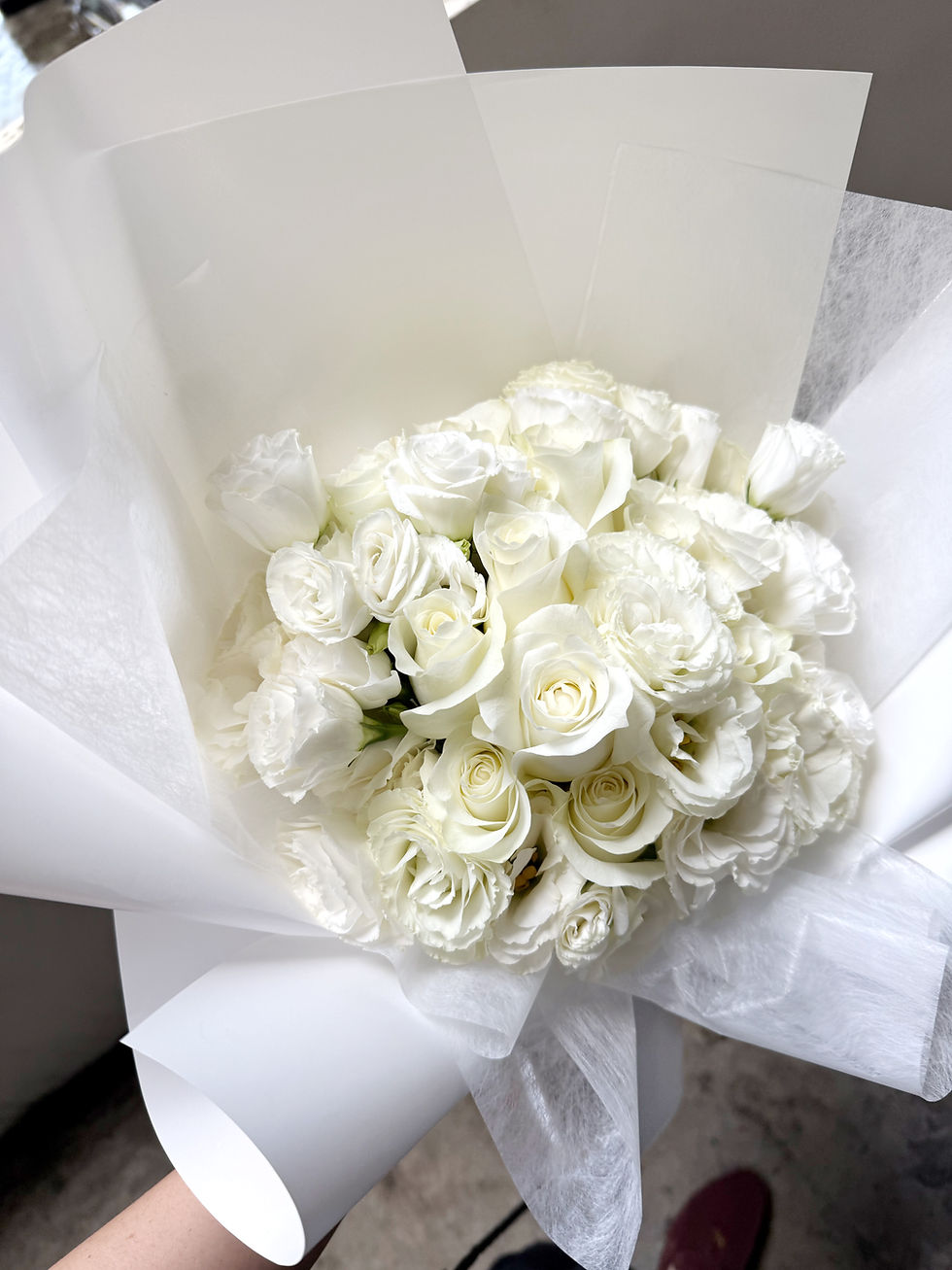 Thumbnail: Close-up of fresh white roses and white lisianthus arranged in an elegant bouquet