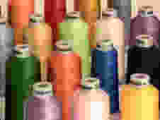 assorted color threads on white surface