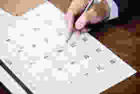 person pinpointing pen on calendar