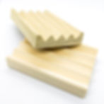 Two wooden soap dishes sitting on each other on a white background