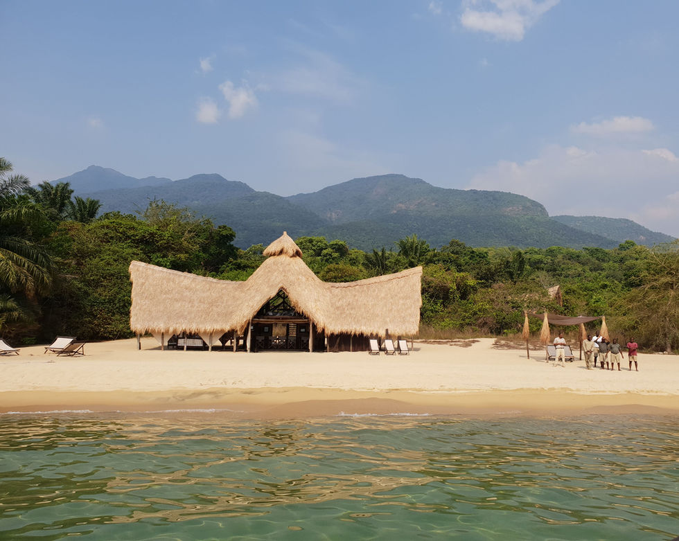 The thatched main area of Greystoke Mahale Lodge in Tanzania sits on a sandy bay of Lake Tanganyika.