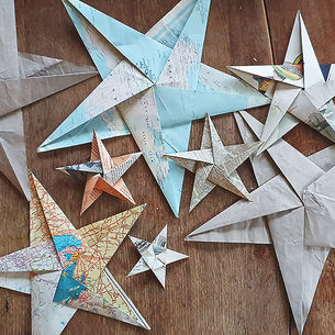 A collection of origami paper stars made from vintage papers including old maps, book pages and music.