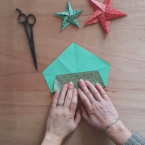 Fold the bottom edge of your pentagon up so the corners meet the creases.