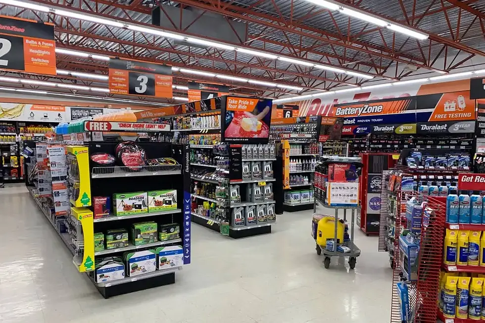 Auto parts store interior with aisles, products, and signage for shopping needs.