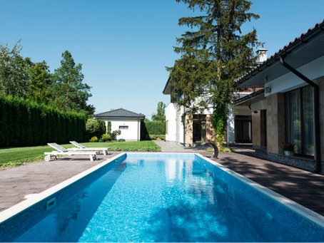 View of house, garden and swimming pool with sunbeds