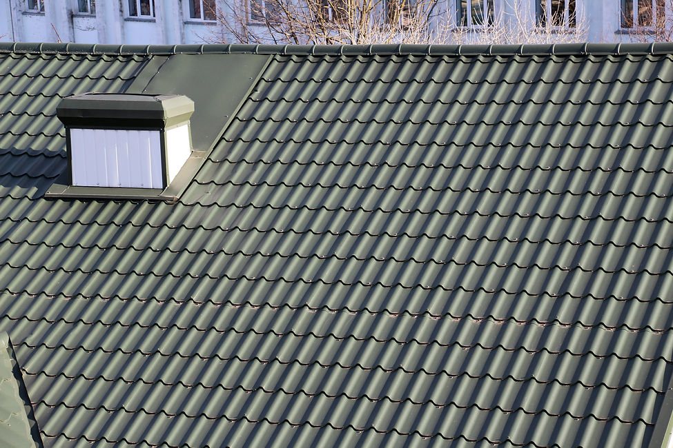 Toit en tuiles vertes avec petite lucarne blanche