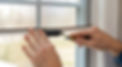 Hands using a spline roller tool to install a window screen