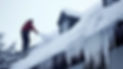 A man removes icicles while cleaning the roof of a house, ensuring safety and maintenance during winter conditions